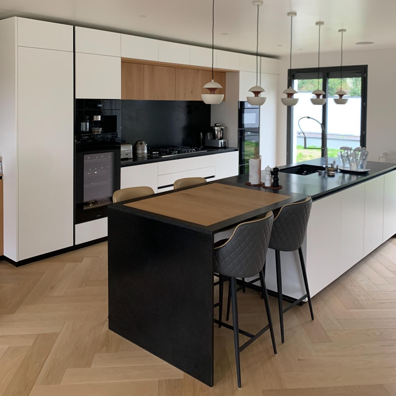 Cuisine blanche et îlot noir avec table en bois