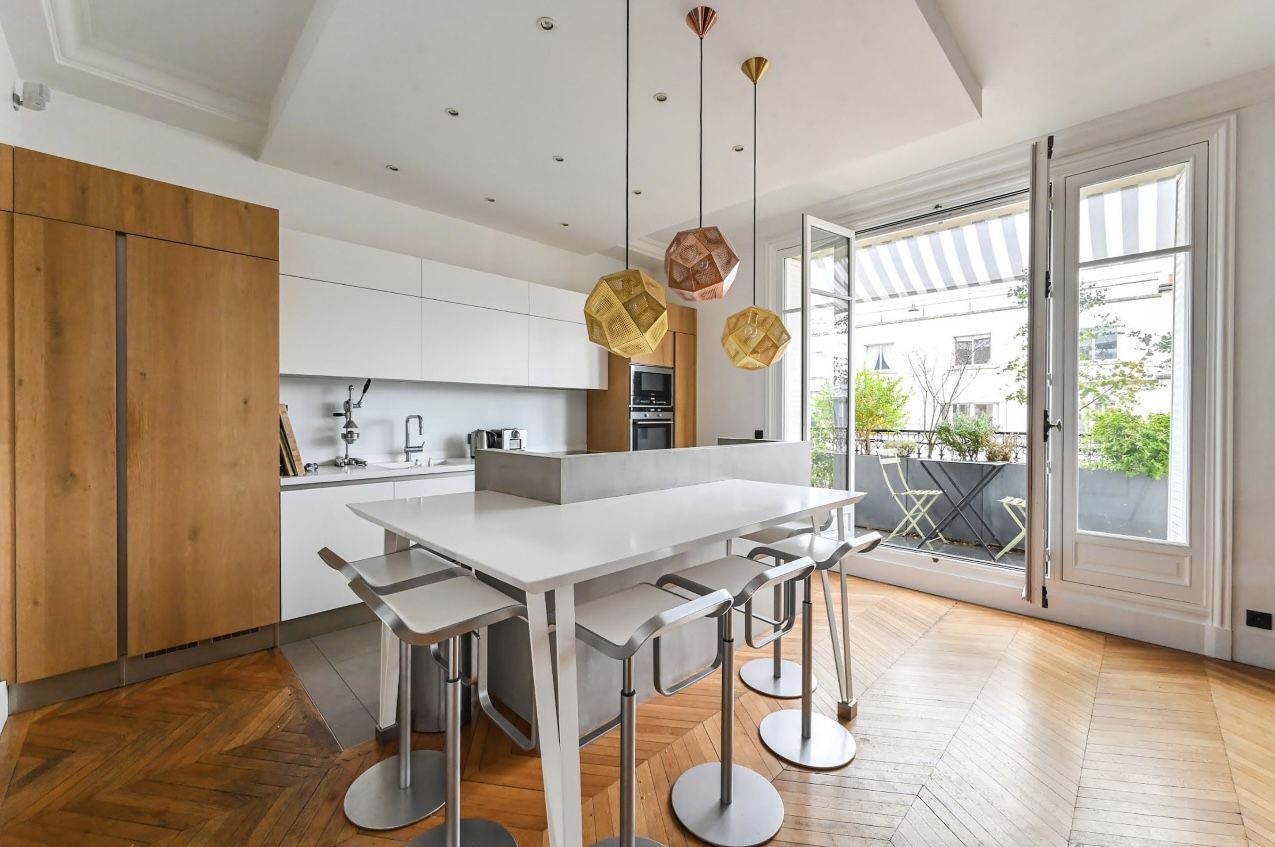 Cuisine blanche avec îlot repas en appartement parisien